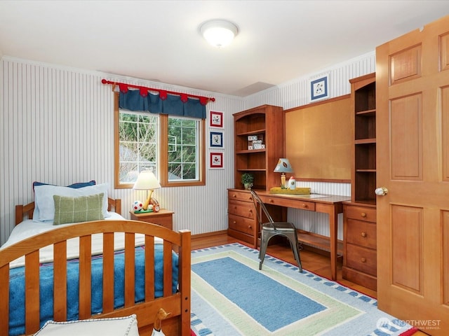 bedroom featuring wallpapered walls and wood finished floors