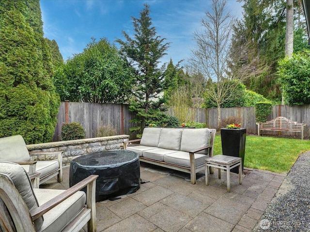 view of patio featuring a fenced backyard and an outdoor living space with a fire pit