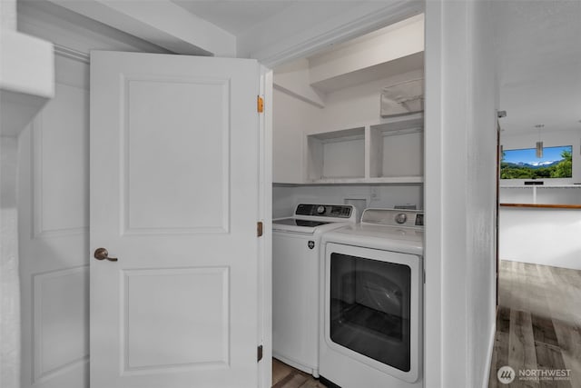 washroom with cabinet space, independent washer and dryer, and wood finished floors