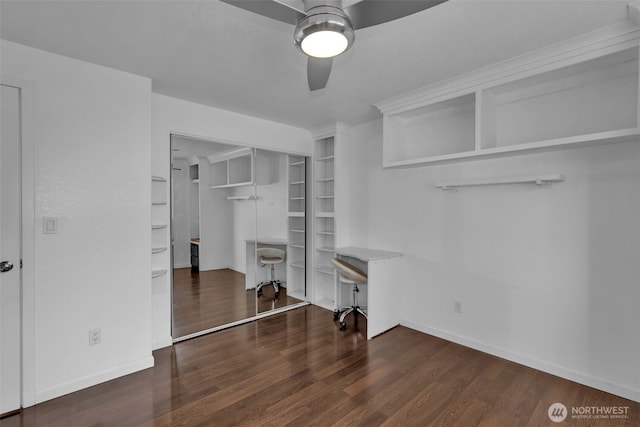 interior space featuring a ceiling fan, baseboards, and wood finished floors