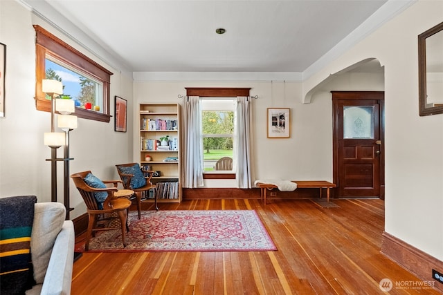 sitting room with wood-type flooring and arched walkways