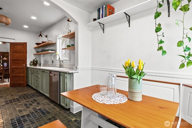 kitchen with a wainscoted wall, open shelves, a sink, light countertops, and dishwasher