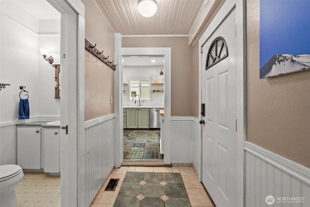 bathroom with vanity, tile patterned floors, visible vents, and wainscoting