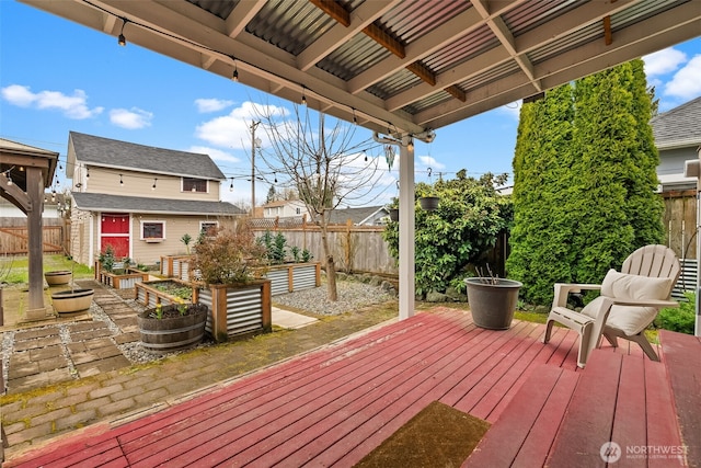 wooden deck featuring an outbuilding, a garden, and a fenced backyard