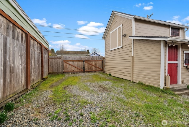 view of yard with fence, driveway, and a gate