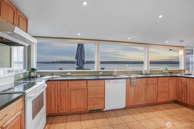 kitchen featuring dark countertops, white appliances, a sink, and under cabinet range hood