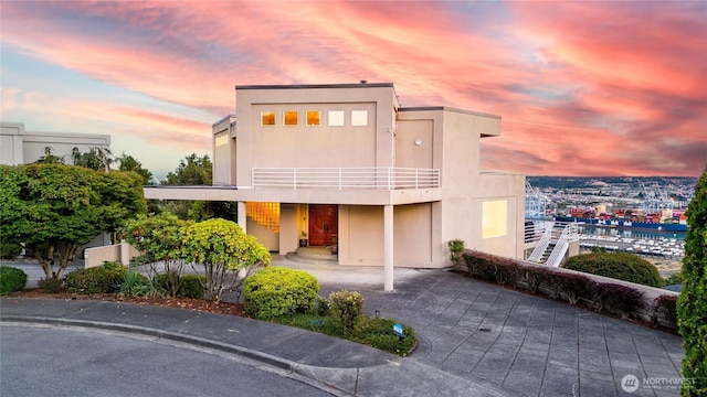 view of front of house with a balcony and stucco siding