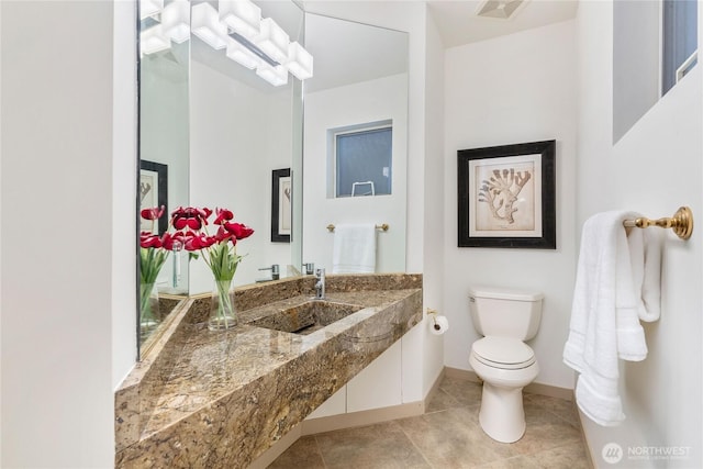 bathroom featuring visible vents, toilet, vanity, baseboards, and tile patterned floors