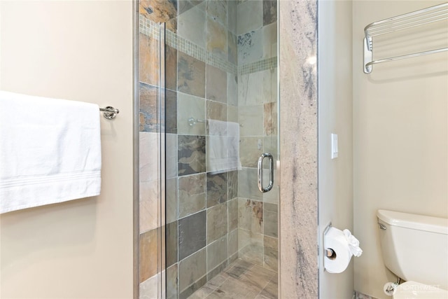 full bath featuring a shower stall and toilet