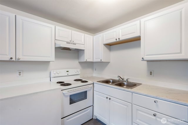 kitchen with a sink, under cabinet range hood, light countertops, and electric stove