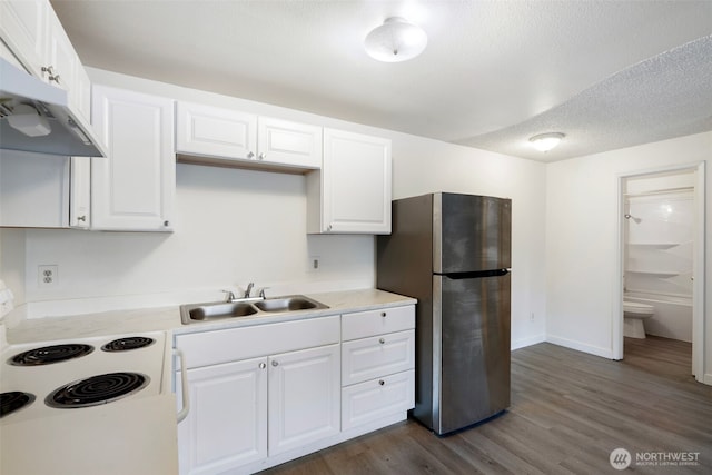 kitchen featuring white range with electric cooktop, freestanding refrigerator, under cabinet range hood, white cabinetry, and a sink