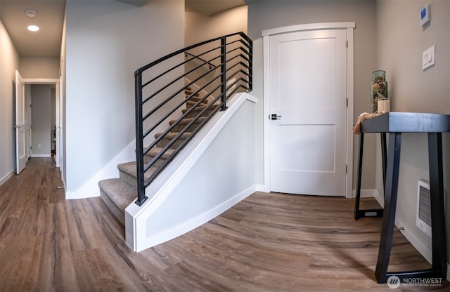 stairway with recessed lighting, wood finished floors, and baseboards