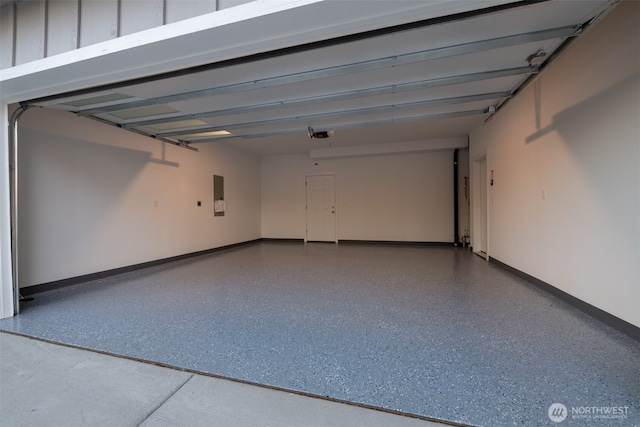 garage featuring electric panel and baseboards