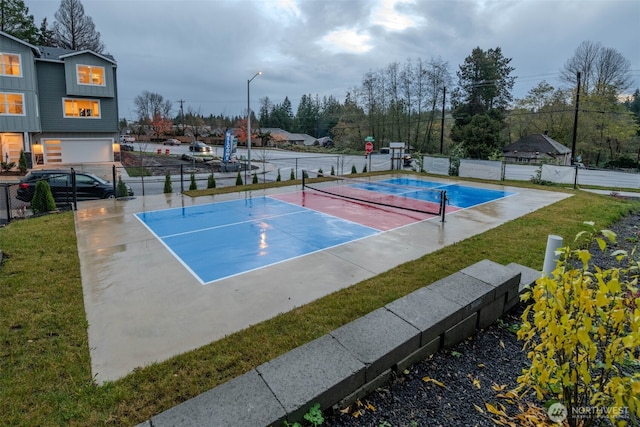 view of tennis court with community basketball court, a lawn, and fence