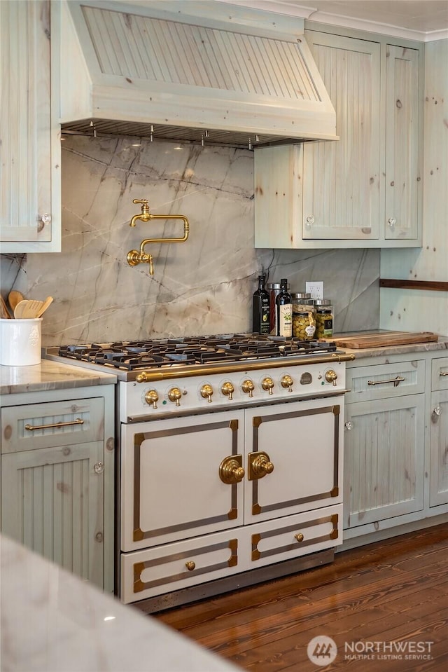 kitchen with double oven range, dark wood finished floors, backsplash, and premium range hood