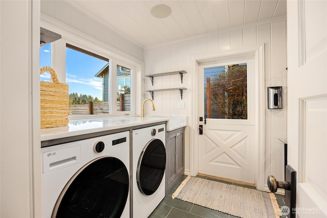 laundry room with dark tile patterned floors, independent washer and dryer, and crown molding