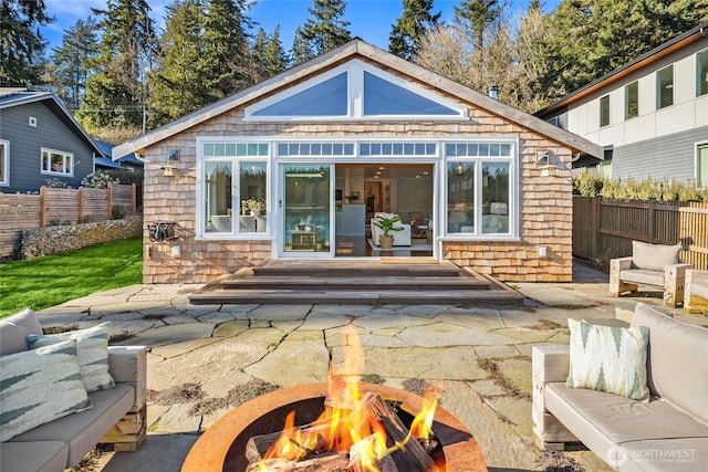 back of house featuring a patio area, an outdoor living space with a fire pit, fence, and an outbuilding