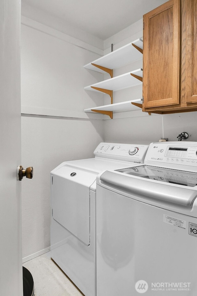 washroom featuring washing machine and dryer and cabinet space