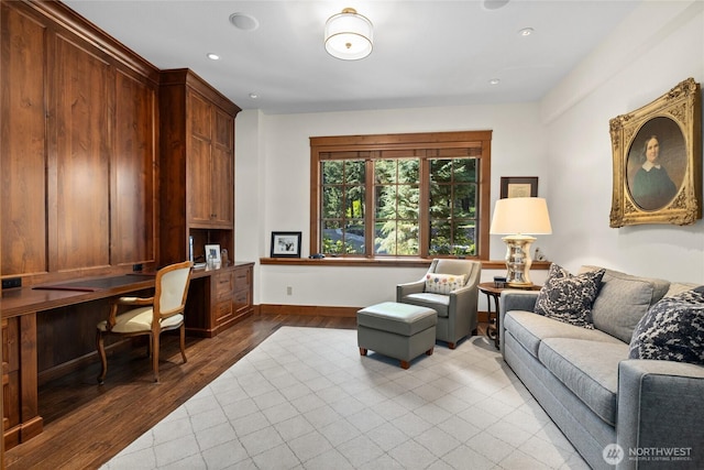 living room featuring baseboards, built in desk, wood finished floors, and recessed lighting