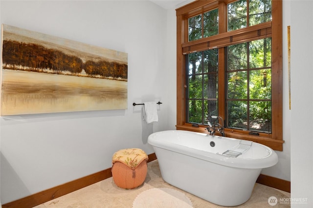 bathroom featuring a soaking tub and baseboards