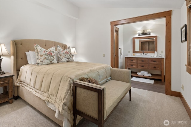 bedroom featuring baseboards, carpet flooring, vaulted ceiling, and a sink