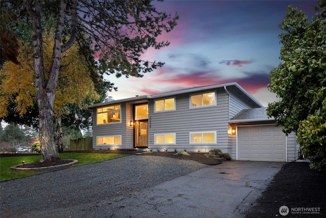 bi-level home featuring aphalt driveway and a garage