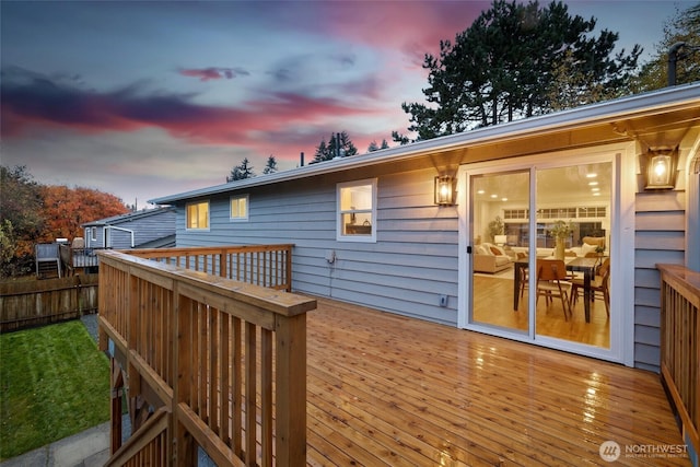 deck at dusk featuring fence