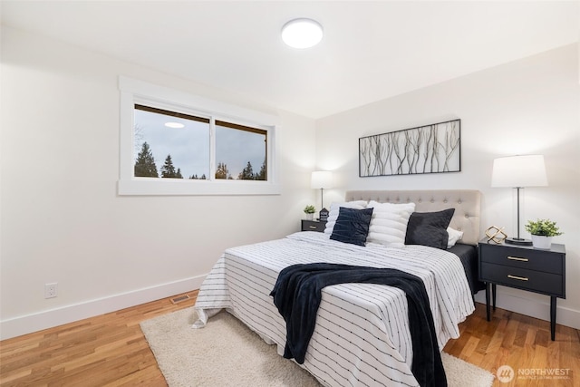 bedroom featuring baseboards and wood finished floors