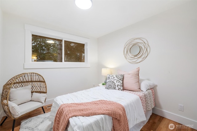 bedroom with baseboards and wood finished floors