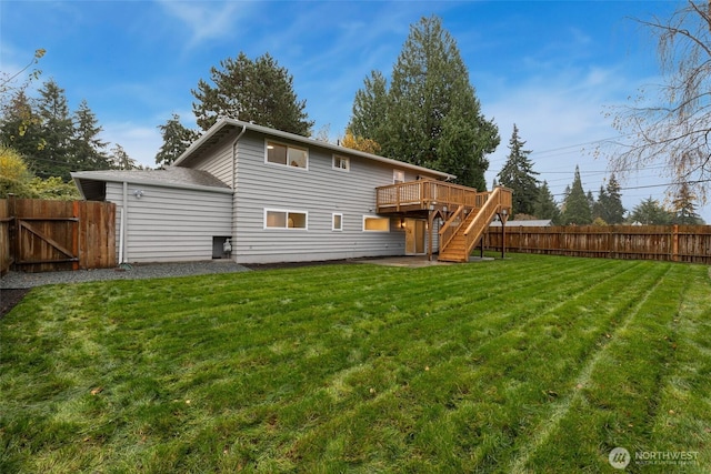 back of property featuring a deck, fence, a lawn, and stairs