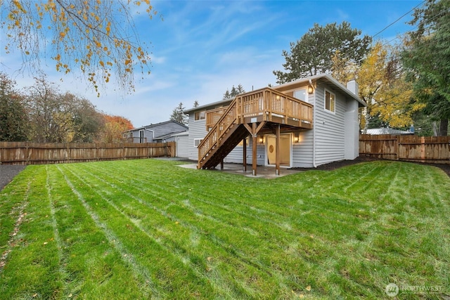 back of property with a lawn, a patio area, a fenced backyard, a wooden deck, and stairs