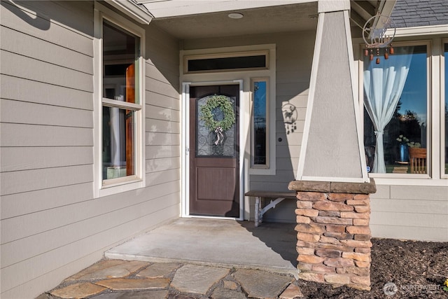 doorway to property with a shingled roof