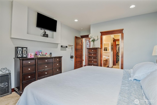 bedroom with ensuite bath, light colored carpet, and recessed lighting