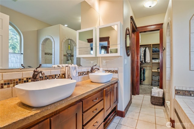 full bath with double vanity, tile patterned flooring, decorative backsplash, and a sink