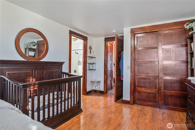 bedroom with a closet, baseboards, and wood finished floors