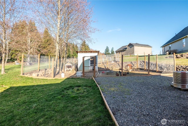 view of yard with an outbuilding, a garden, fence, and exterior structure