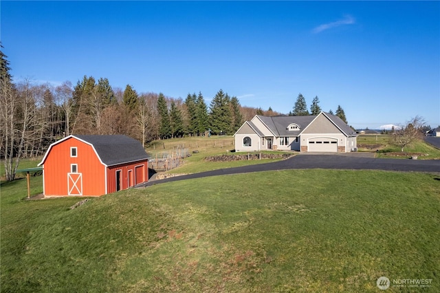 view of front of home featuring a barn, a front yard, an outbuilding, and a gambrel roof