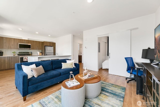 living room with light wood-style flooring and recessed lighting