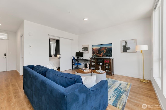 living room featuring baseboards, recessed lighting, and light wood-style floors