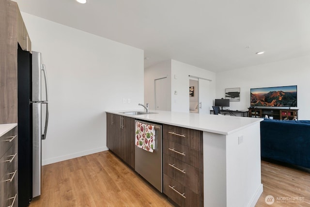 kitchen with stainless steel appliances, modern cabinets, a peninsula, and light countertops