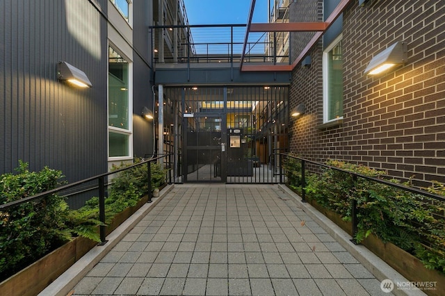 property entrance featuring brick siding and a balcony