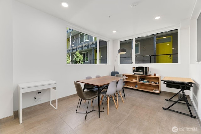 tiled dining room with baseboards and recessed lighting