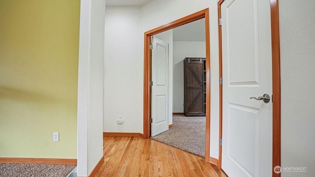 corridor featuring baseboards and light wood-style floors