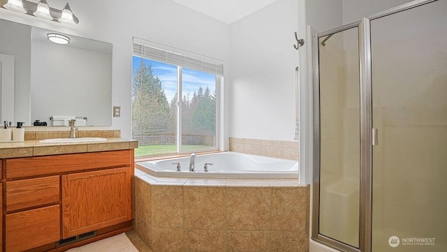 bathroom featuring a garden tub, a stall shower, and vanity