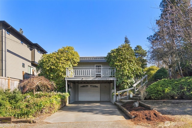 view of front facade with an attached garage, driveway, and stairway