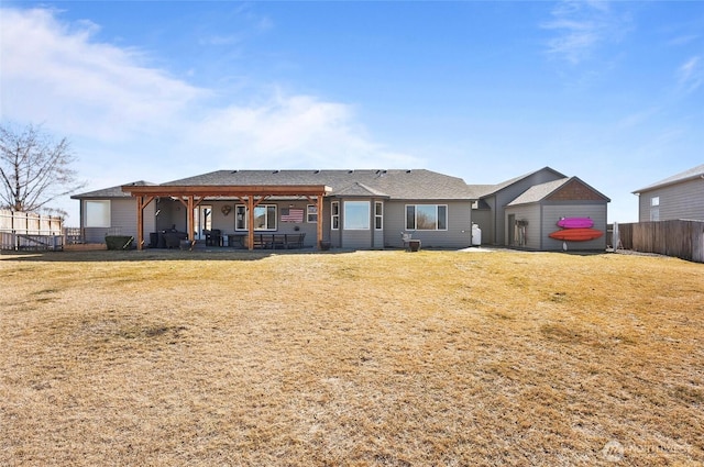 back of house with fence, a patio, and a lawn