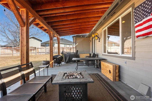 view of patio featuring a grill, fence, and a fire pit