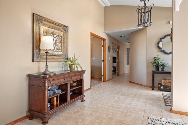corridor with light tile patterned flooring and baseboards