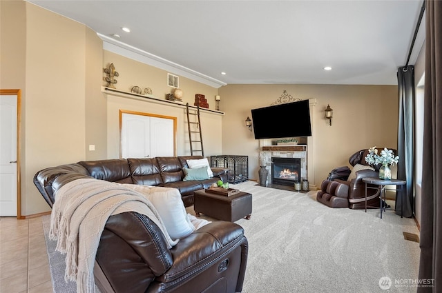 living room featuring lofted ceiling, light tile patterned floors, recessed lighting, a fireplace with flush hearth, and visible vents