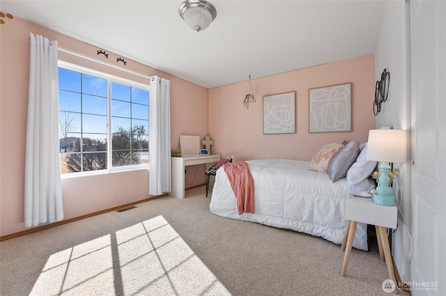 carpeted bedroom featuring visible vents and baseboards